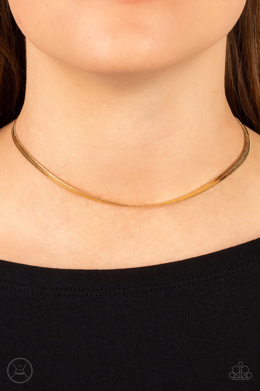 strand of glistening gold snake chain loops around the neck