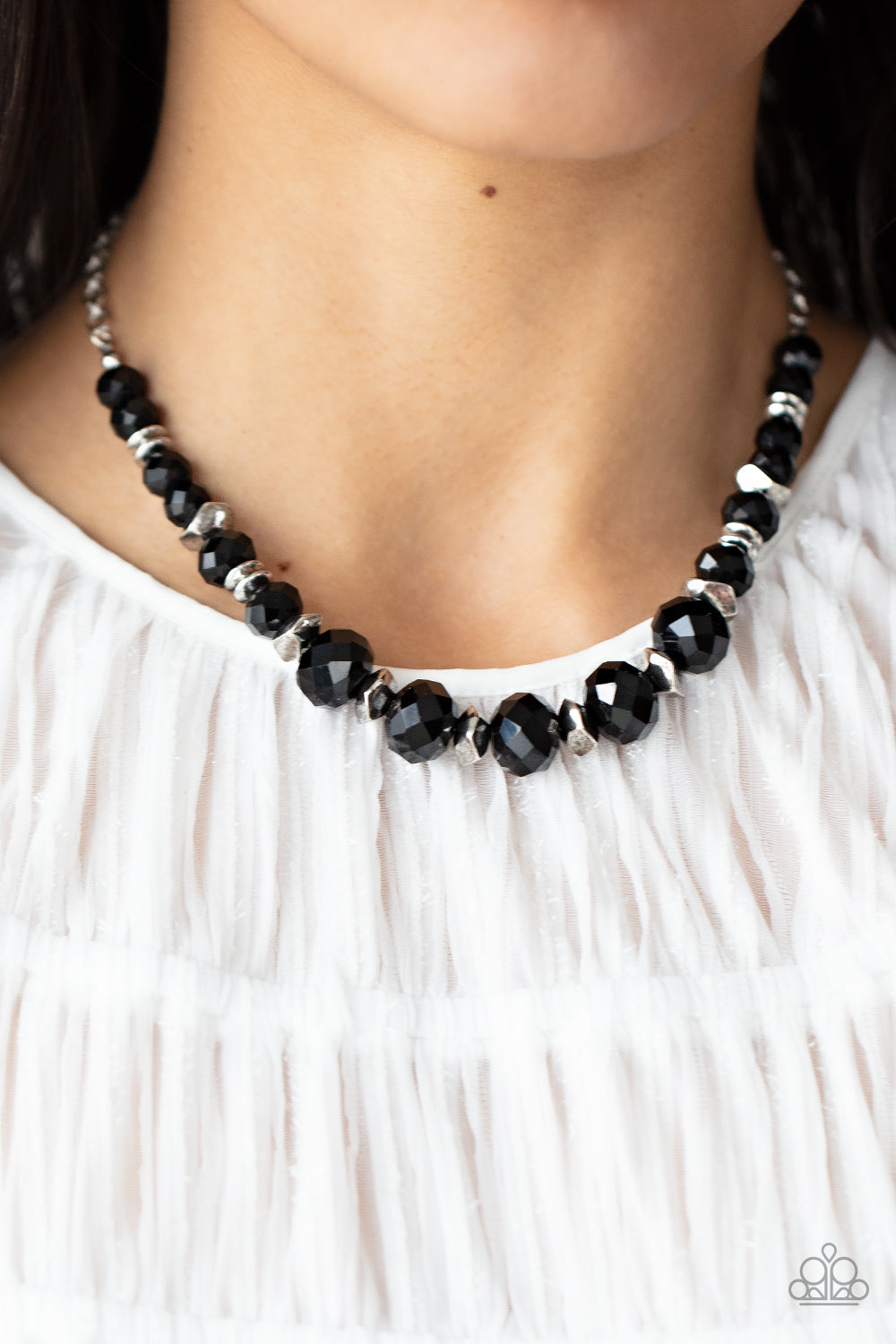 silver discs and faceted silver accents, faceted black crystal-like gems are threaded along an invisible wire below the collar
