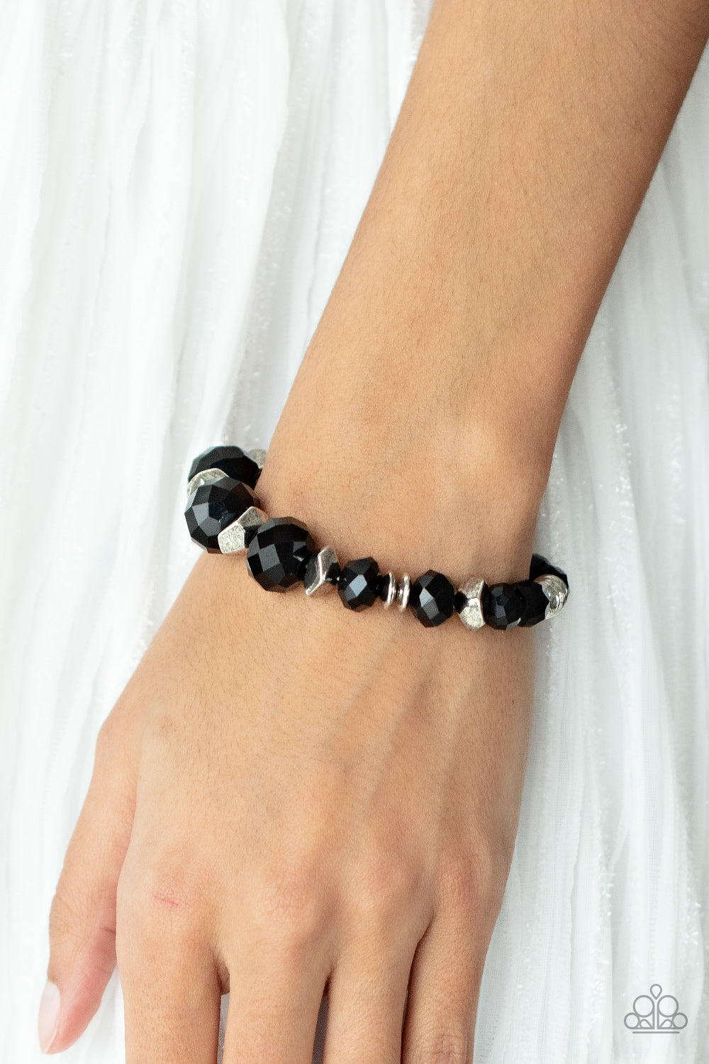 silver discs and faceted silver accents, faceted black crystal-like gems are threaded along stretchy bands around the wrist