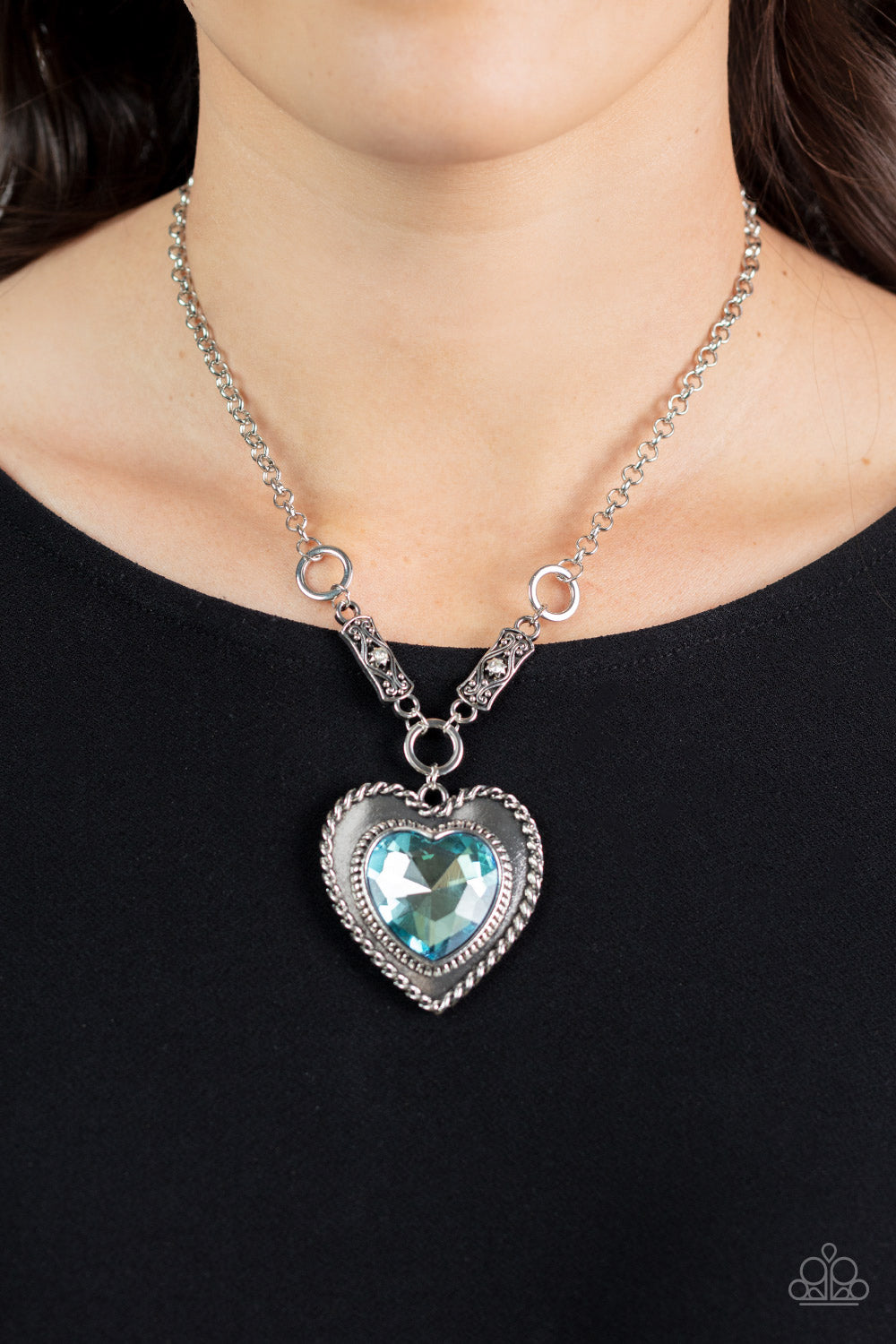 oversized blue heart gem is pressed into a silver heart frame 