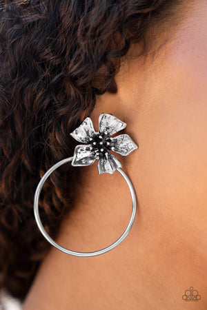 a shimmery silver buttercup blooms atop an oversized silver hoop