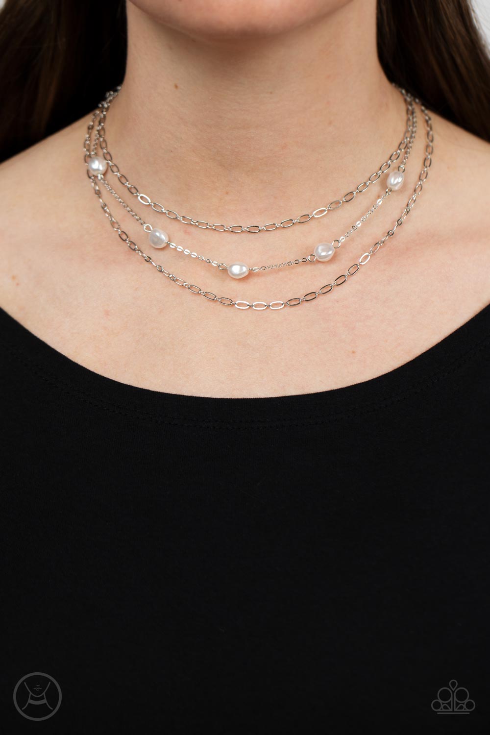 Infused with two oval-linked silver chains, imperfect white pearls adorn a dainty silver chain around the neck