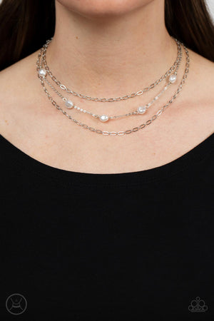 Infused with two oval-linked silver chains, imperfect white pearls adorn a dainty silver chain around the neck