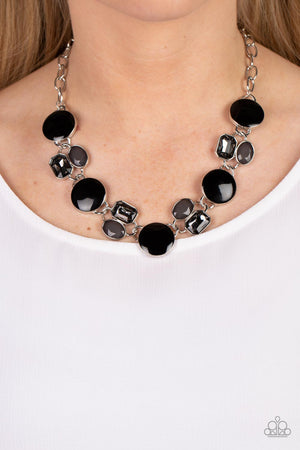 Sparkling smoky gems combine with black beads and alternate across the collar with oversized discs painted in black enamel