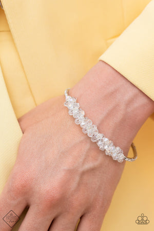 clear crystal-like beads are brushed in an iridescent shimmer and gather in the center of a thin, flexible silver cuff